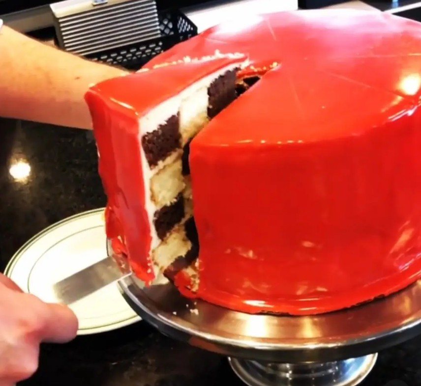 A layered checkerboard cake with a red mirror glaze, made by Michael Heston